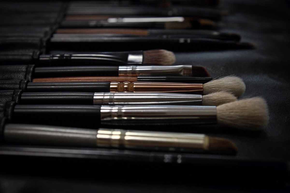 Assorted professional makeup brushes and eyeshadow palettes